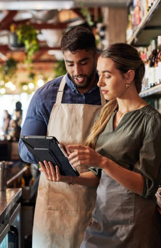 Café staff reviewing the day's numbers on a tablet