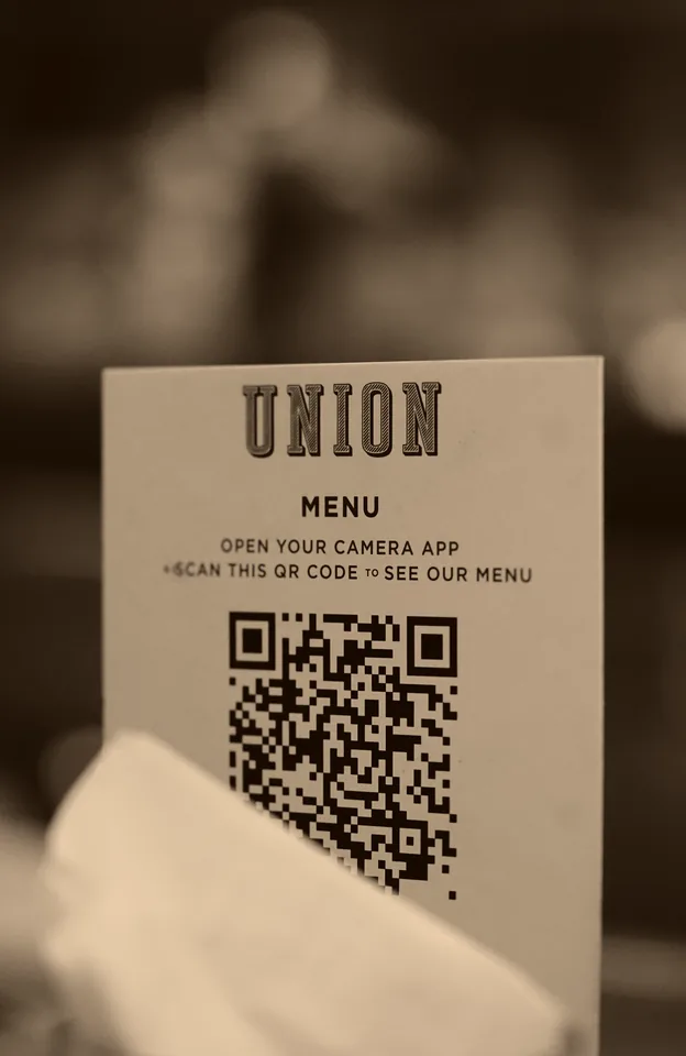 A guest scanning a QR menu at a food-court table
