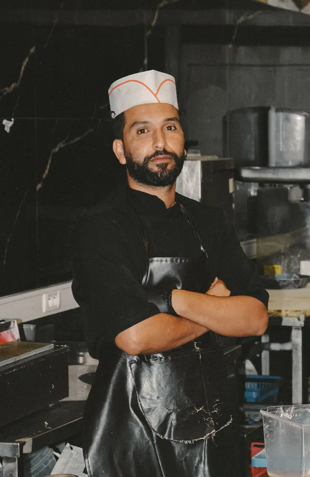 A chef in the kitchen with orders on the display screen