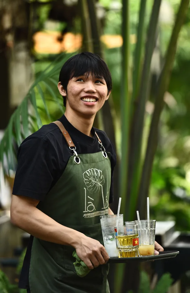 A waiter taking an order beside the table on a handheld